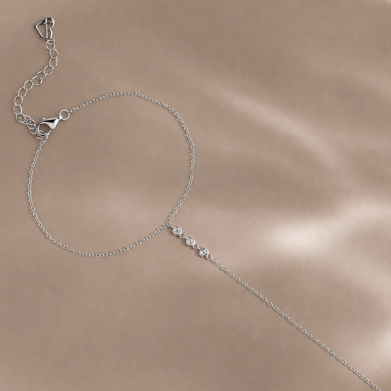 Silver chain necklace on a beige background